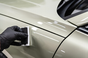 Technician sanding vehicle surface